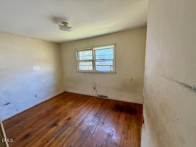 133 Hill Street Roxboro, NC 27573 - Photo 12 of 15 an empty room with wooden floor and windows