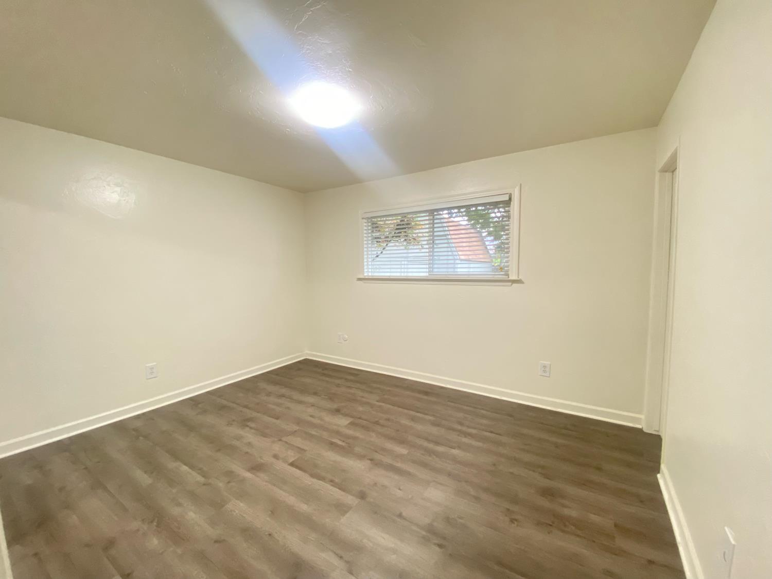 2301 McRitchie Way Modesto, CA 95355 - Photo 14 of 22 an empty room with wooden floor and window
