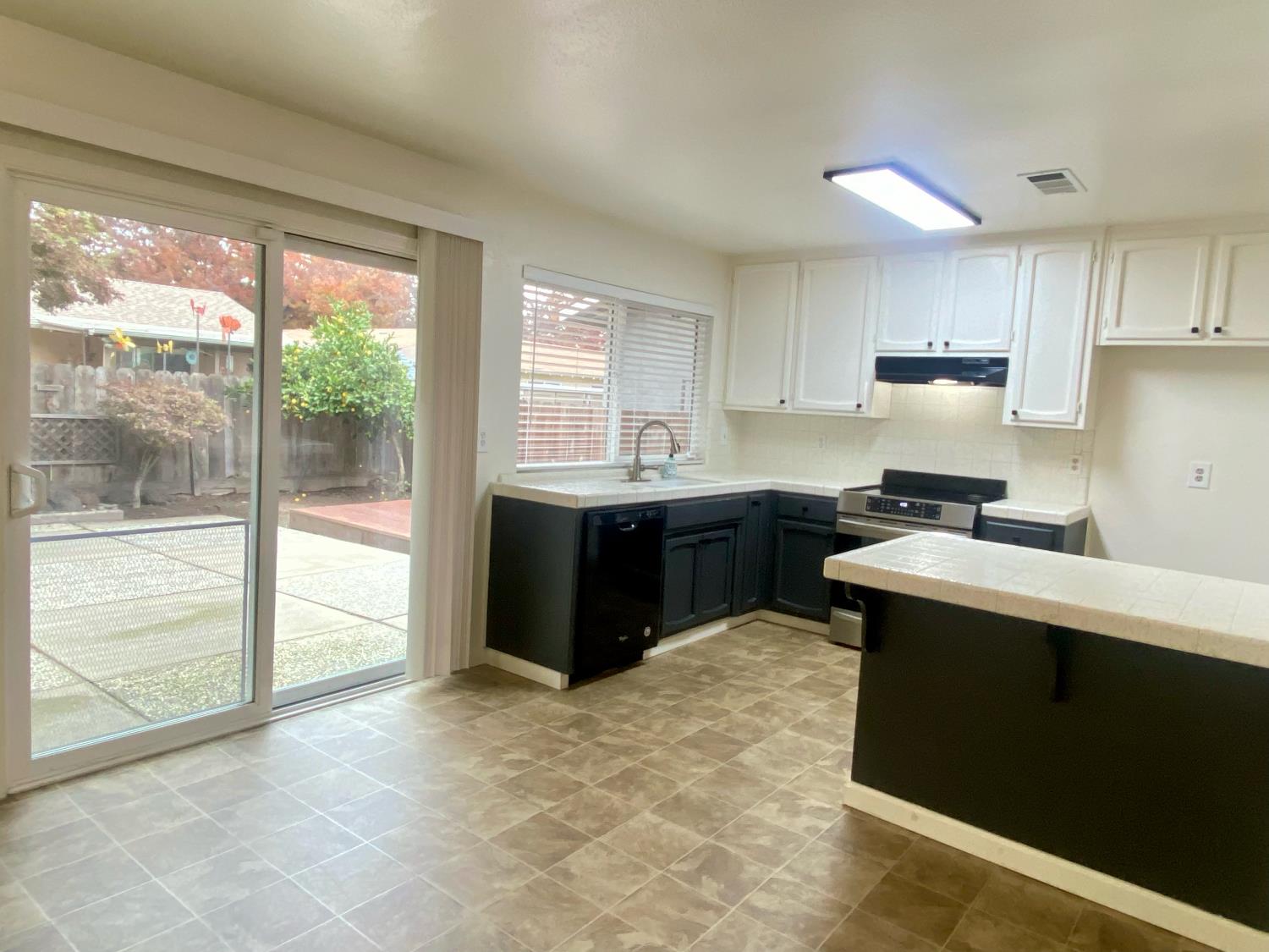 2301 McRitchie Way Modesto, CA 95355 - Photo 9 of 22 a kitchen with a stove a sink and a refrigerator