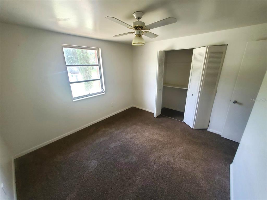 14576 Southwest 34th Terrace Road Ocala, FL 34473 - Photo 5 of 11 an empty room with windows and ceiling fan