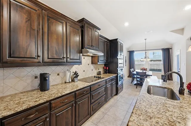 a kitchen with stainless steel appliances granite countertop wooden cabinets a sink and dishwasher