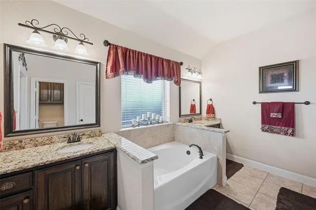 a bathroom with a tub sink and mirror