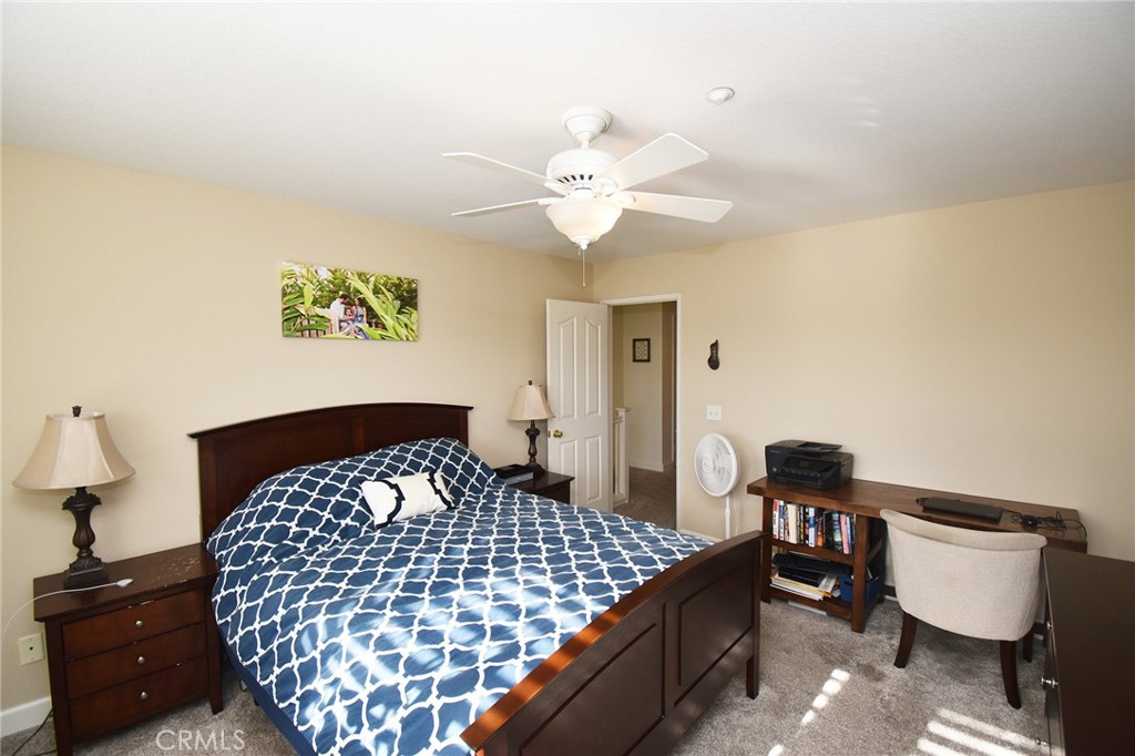 7353 Ellena West, Unit 70 Rancho Cucamonga, CA 91730 - Photo 13 of 40 a bedroom with a bed and a lamp on dresser