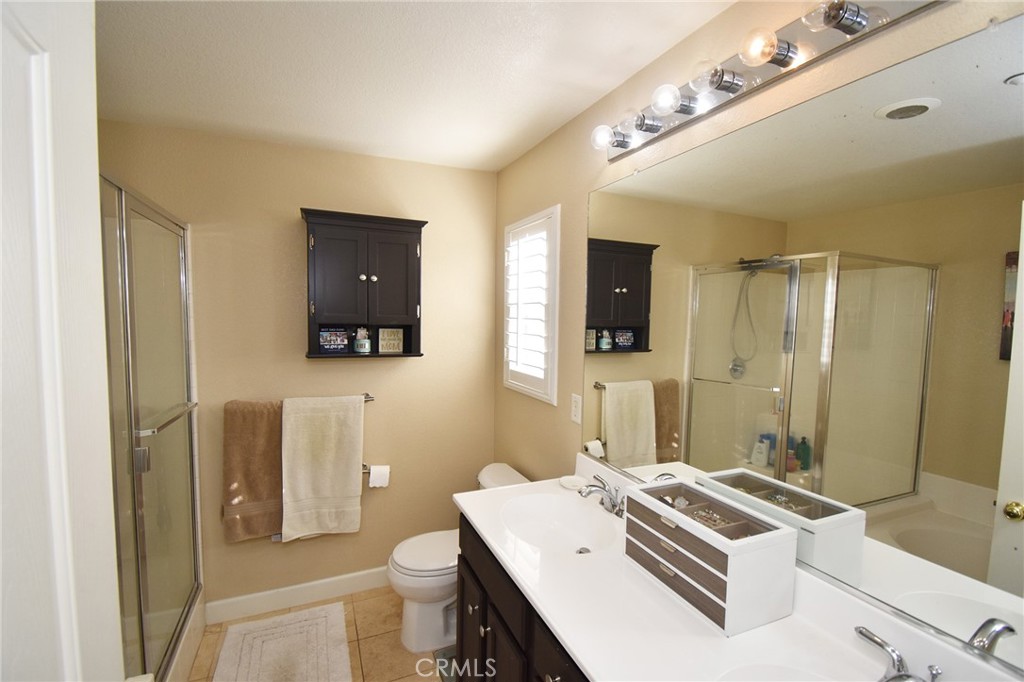 7353 Ellena West, Unit 70 Rancho Cucamonga, CA 91730 - Photo 15 of 40 a bathroom with a sink a toilet a mirror and shower