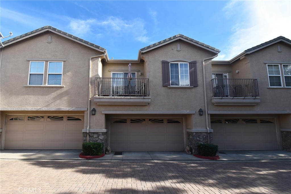 7353 Ellena West, Unit 70 Rancho Cucamonga, CA 91730 - Photo 2 of 40 a front view of a house with a garage