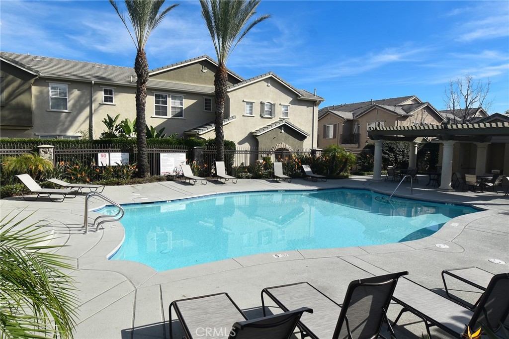 7353 Ellena West, Unit 70 Rancho Cucamonga, CA 91730 - Photo 22 of 40 a front view of a house with swimming pool table and chairs