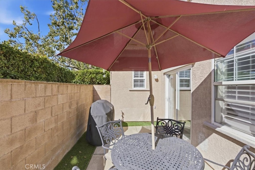 7353 Ellena West, Unit 70 Rancho Cucamonga, CA 91730 - Photo 34 of 40 a patio table and chairs under an umbrella
