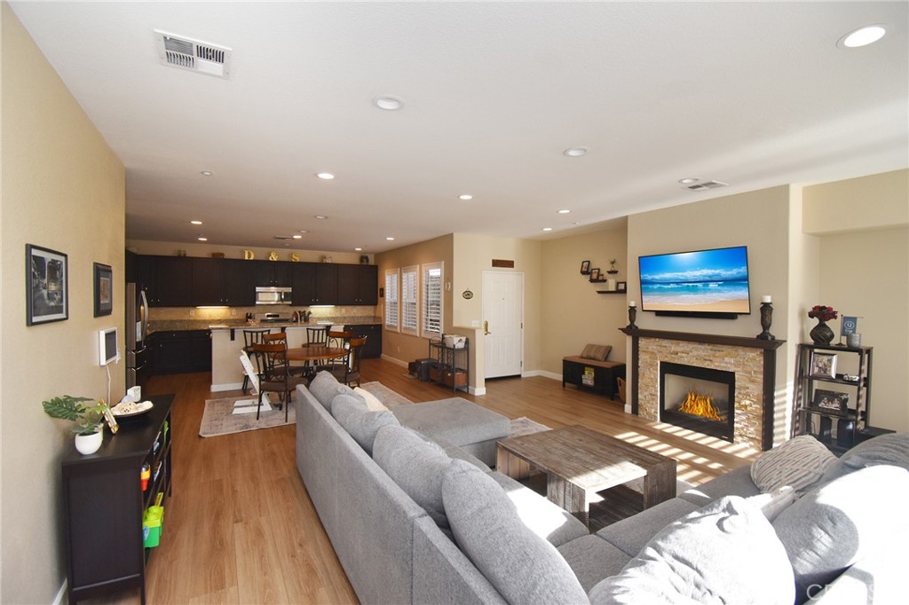 7353 Ellena West, Unit 70 Rancho Cucamonga, CA 91730 - Photo 9 of 40 a living room with furniture a fireplace and a flat screen tv