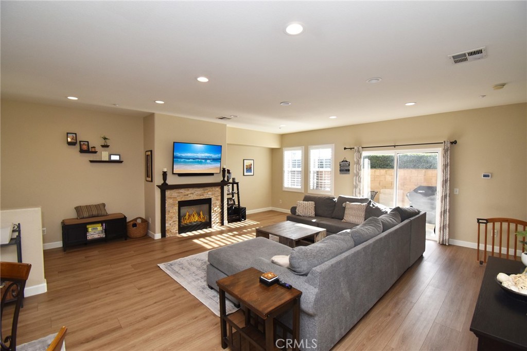 7353 Ellena West, Unit 70 Rancho Cucamonga, CA 91730 - Photo 10 of 40 a living room with fireplace furniture and a wooden floor