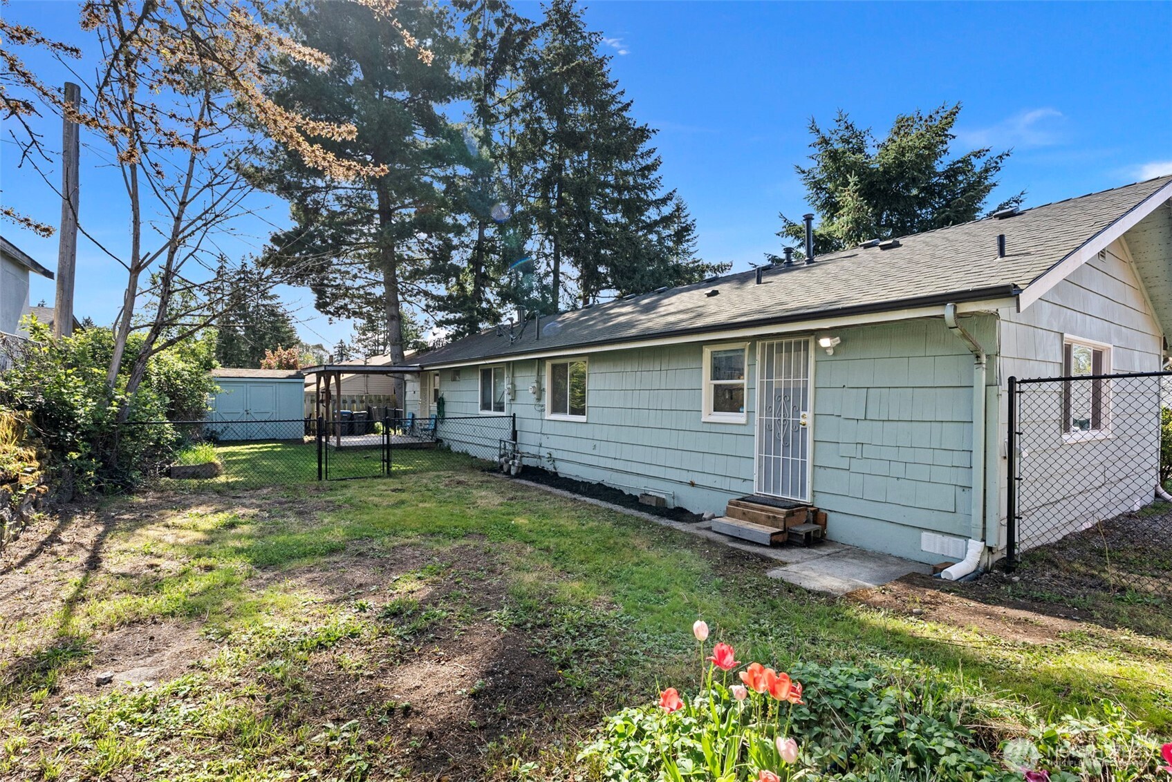 414 Plum Street Bremerton, WA 98310 - Photo 17 of 40 a backyard of a house with wooden fence and plants