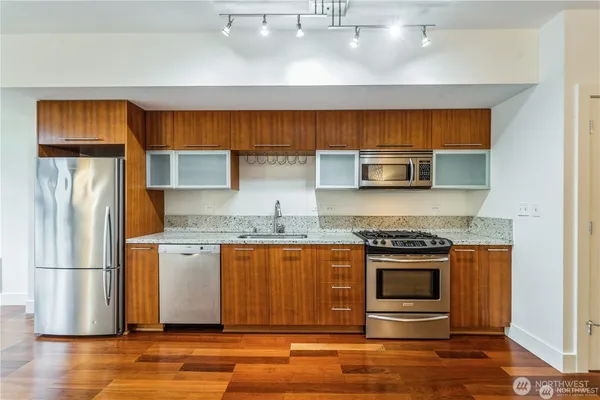 a kitchen with stainless steel appliances granite countertop a stove a refrigerator and a stove top oven