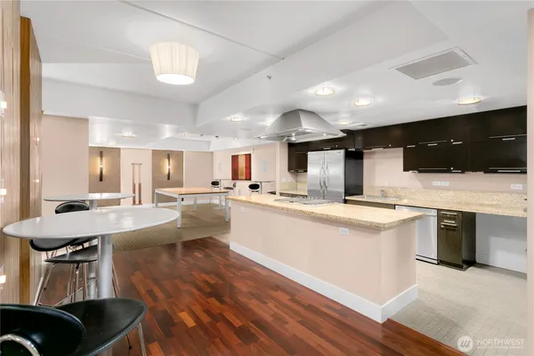 a kitchen with stainless steel appliances kitchen island granite countertop a table chairs sink and cabinets