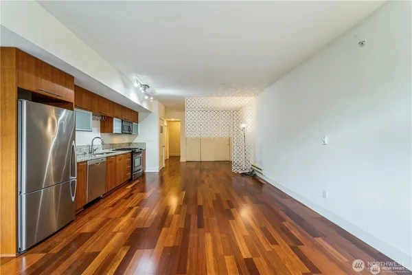 a kitchen with wooden floors and refrigerator