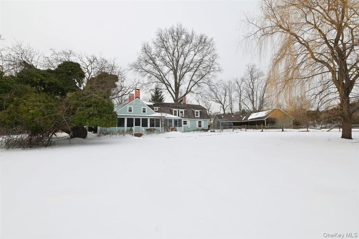 a front view of a house with a yard covered with snow