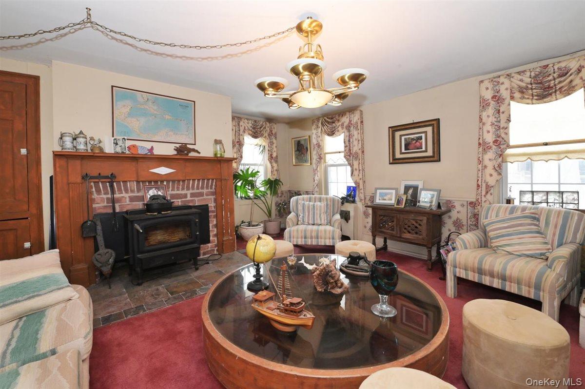 6 Callahan Road Fort Salonga, NY 11768 - Photo 11 of 50 a living room with furniture a fireplace and a chandelier