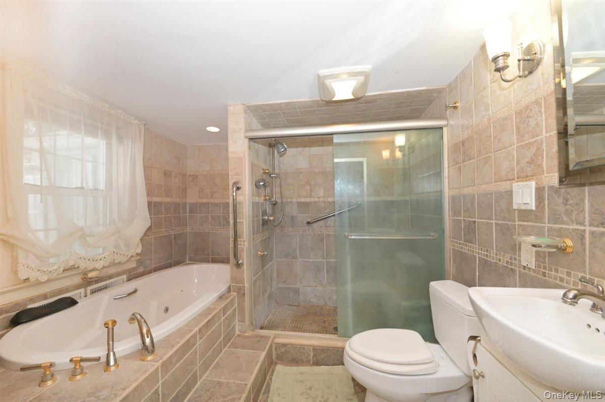 6 Callahan Road Fort Salonga, NY 11768 - Photo 20 of 50 a bathroom with a bathtub shower sink mirror vanity and toilet