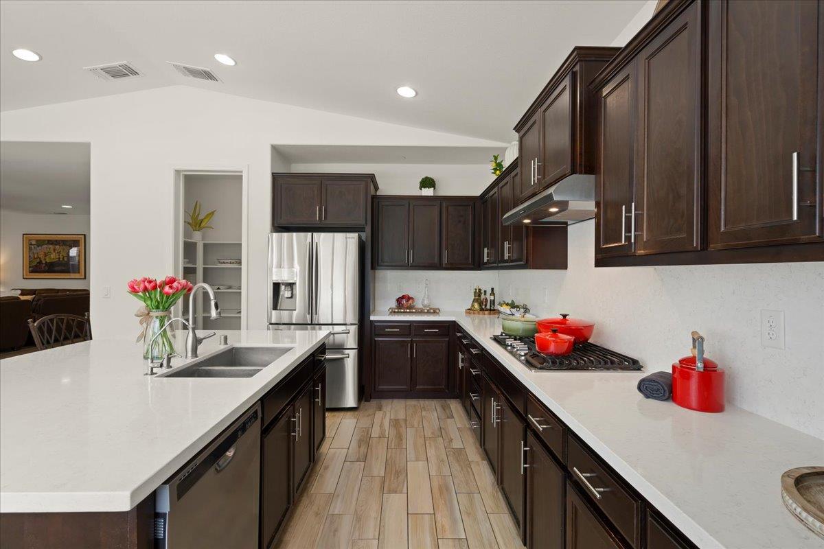 1188 Viognier Way Gilroy, CA 95020 - Photo 28 of 71 a kitchen with a sink dishwasher a stove and a refrigerator with wooden floor