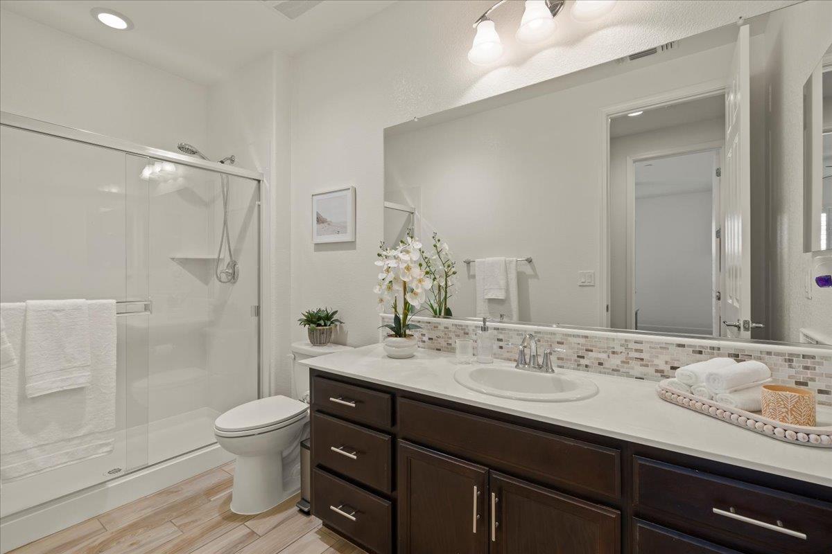 1188 Viognier Way Gilroy, CA 95020 - Photo 34 of 71 a bathroom with a granite countertop sink toilet a shower and a mirror