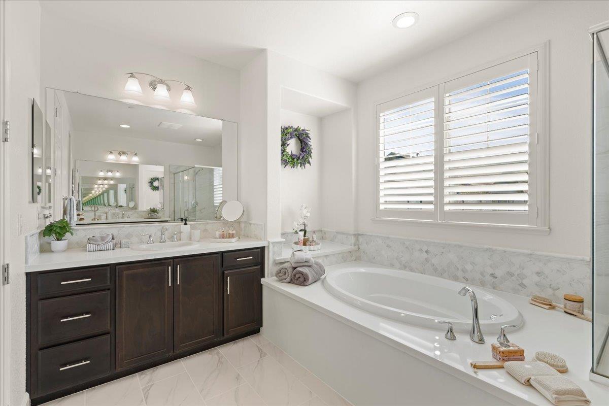 1188 Viognier Way Gilroy, CA 95020 - Photo 47 of 71 a bathroom with a granite countertop bathtub a double vanity sink a window and a mirror