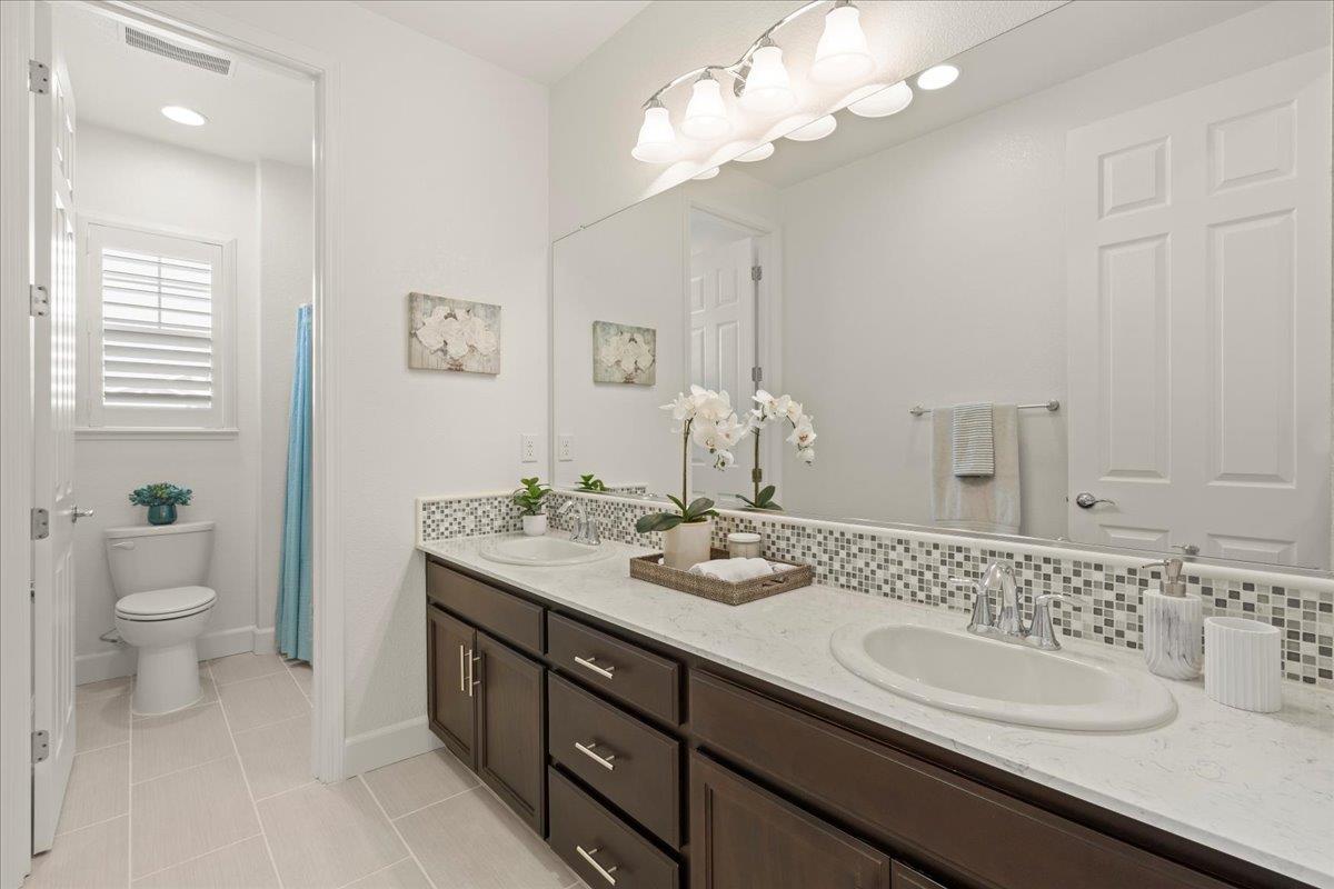 1188 Viognier Way Gilroy, CA 95020 - Photo 51 of 71 a bathroom with a granite countertop sink a toilet and a mirror
