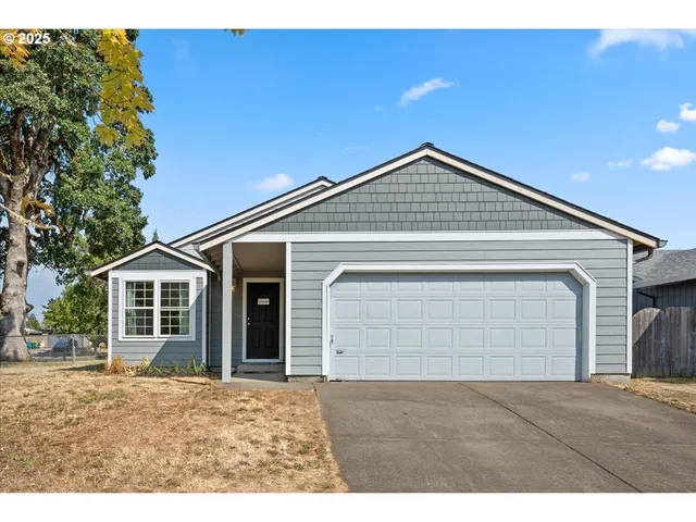 a front view of a house with a garden and yard