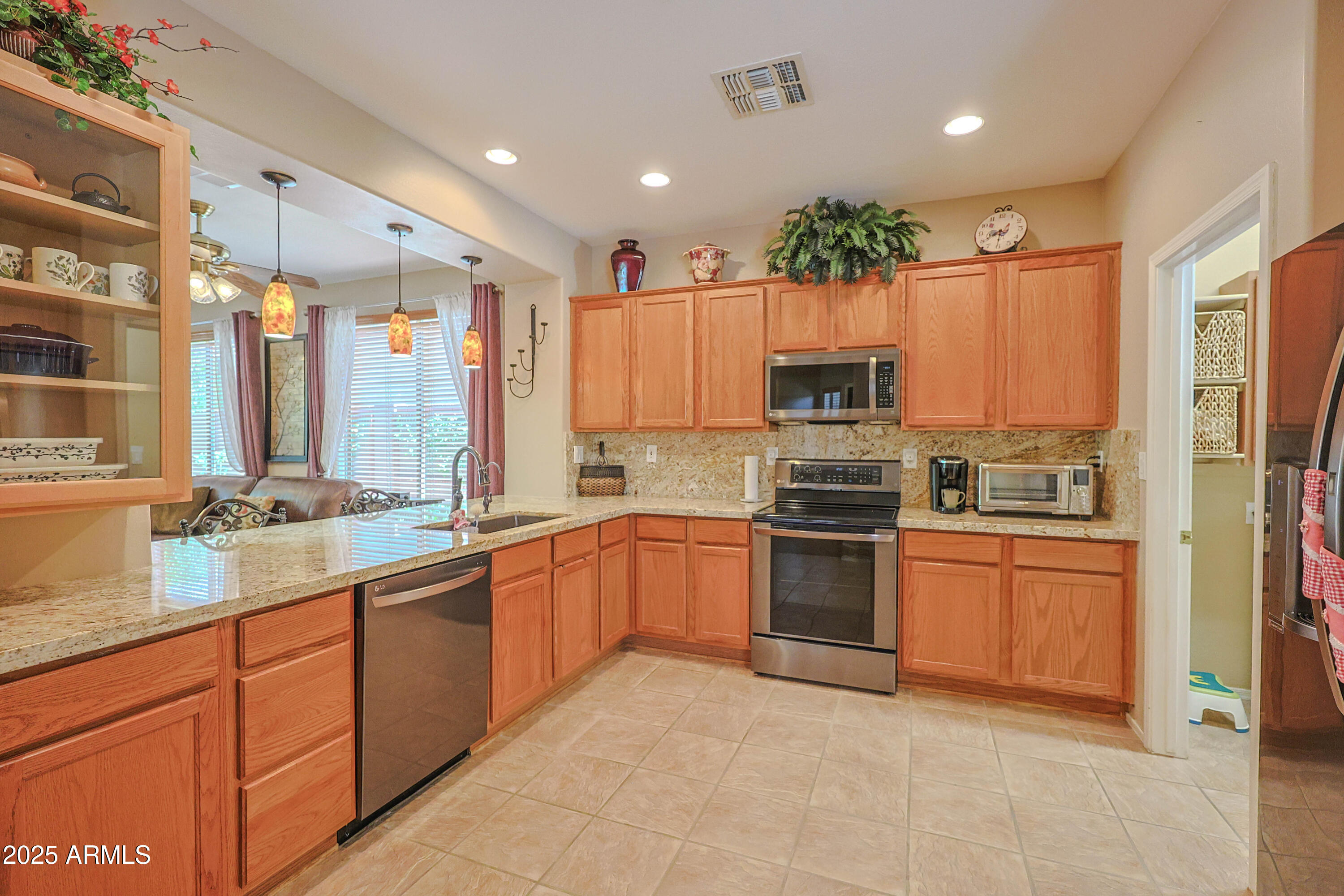 1916 West Spirit Court Anthem, AZ 85086 - Photo 15 of 43 a large kitchen with stainless steel appliances granite countertop a stove top oven a sink and dishwasher