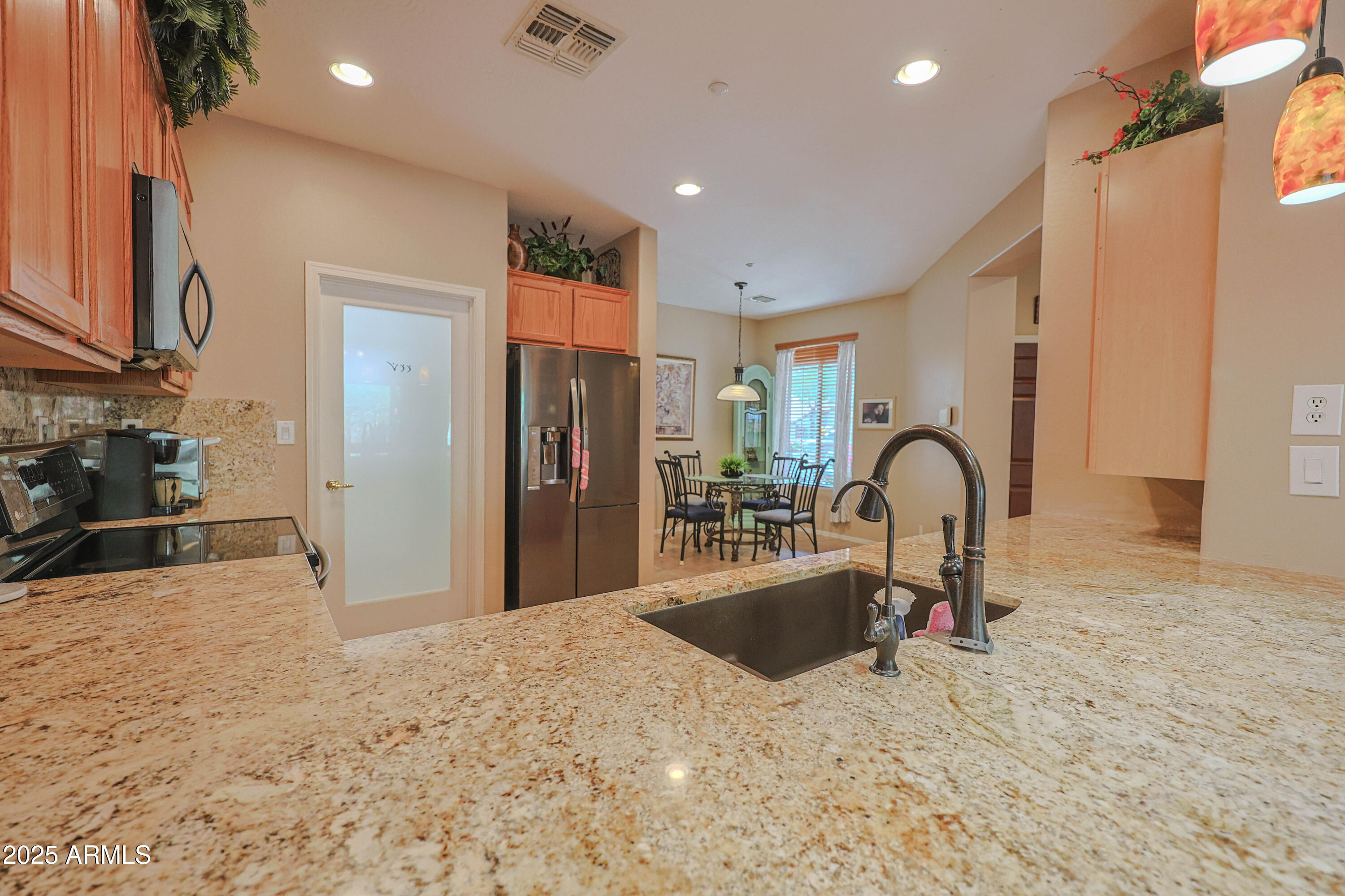 1916 West Spirit Court Anthem, AZ 85086 - Photo 16 of 43 a kitchen with stainless steel appliances kitchen island a sink a refrigerator and a granite counter tops