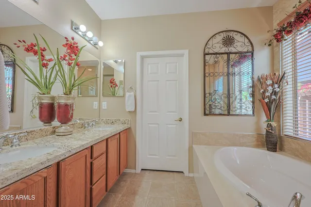 a bathroom with a granite countertop sink a mirror and a bathtub