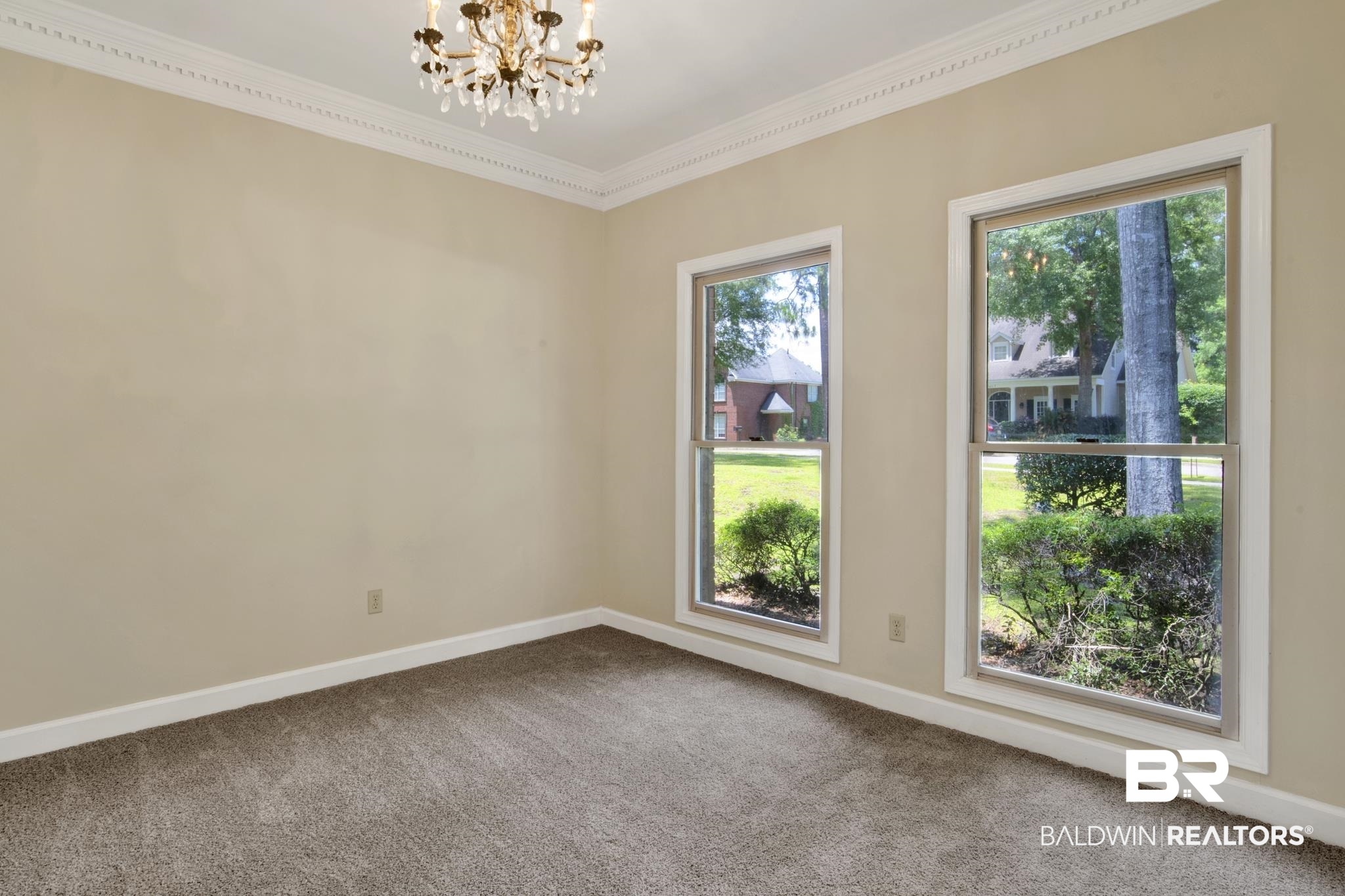6805 Hunters Court Mobile, AL 36695 - Photo 7 of 37 Empty room with a chandelier, dark carpet, crown molding, and baseboards