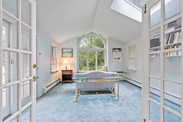 a bedroom with furniture and a large window