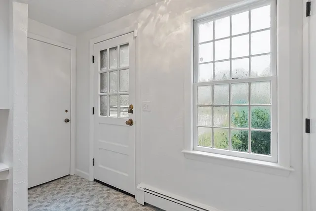 a view of a hallway with wooden floor and entryway