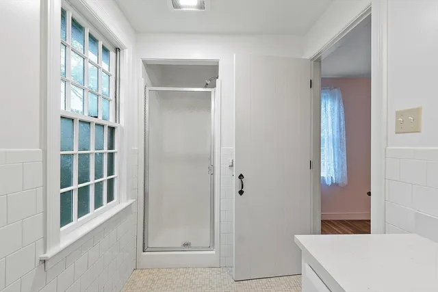 an empty room with wooden floor closet and windows