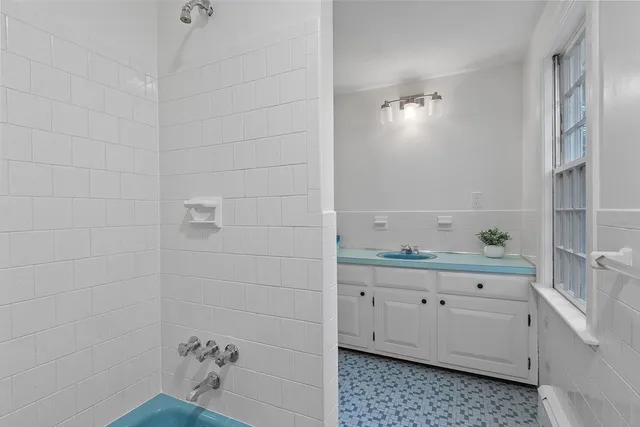a bathroom with a granite countertop sink and a window
