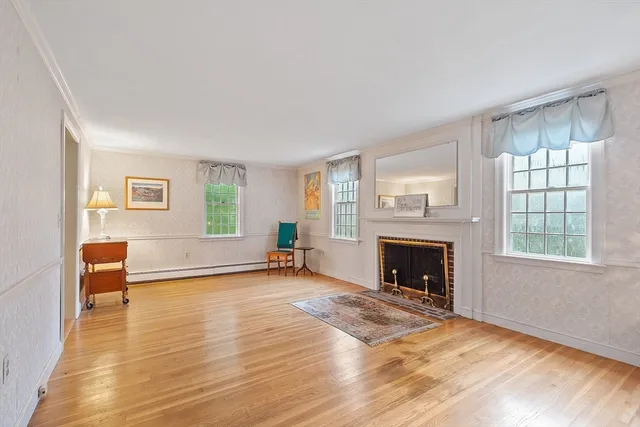 a view of a livingroom with furniture a fireplace and wooden floor