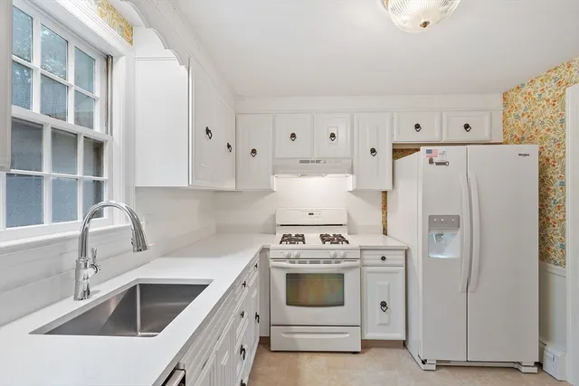a view of kitchen with white cabinets and white appliances