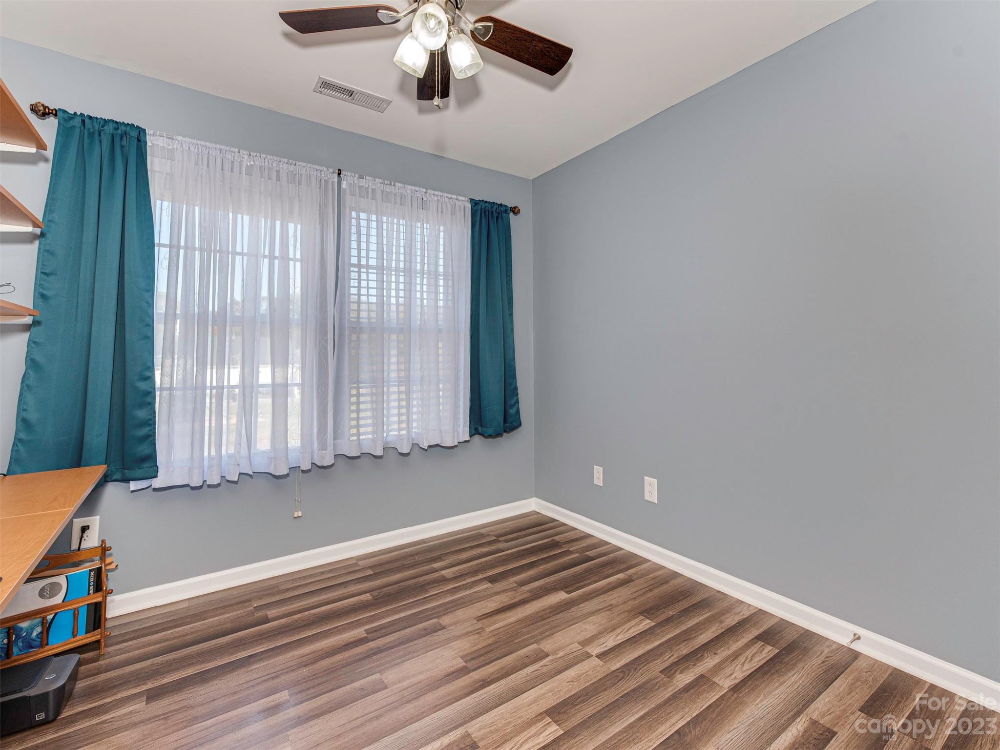 2049 Twilight Lane Monroe, NC 28110 - Photo 29 of 44 an empty room with wooden floor chandelier fan and windows