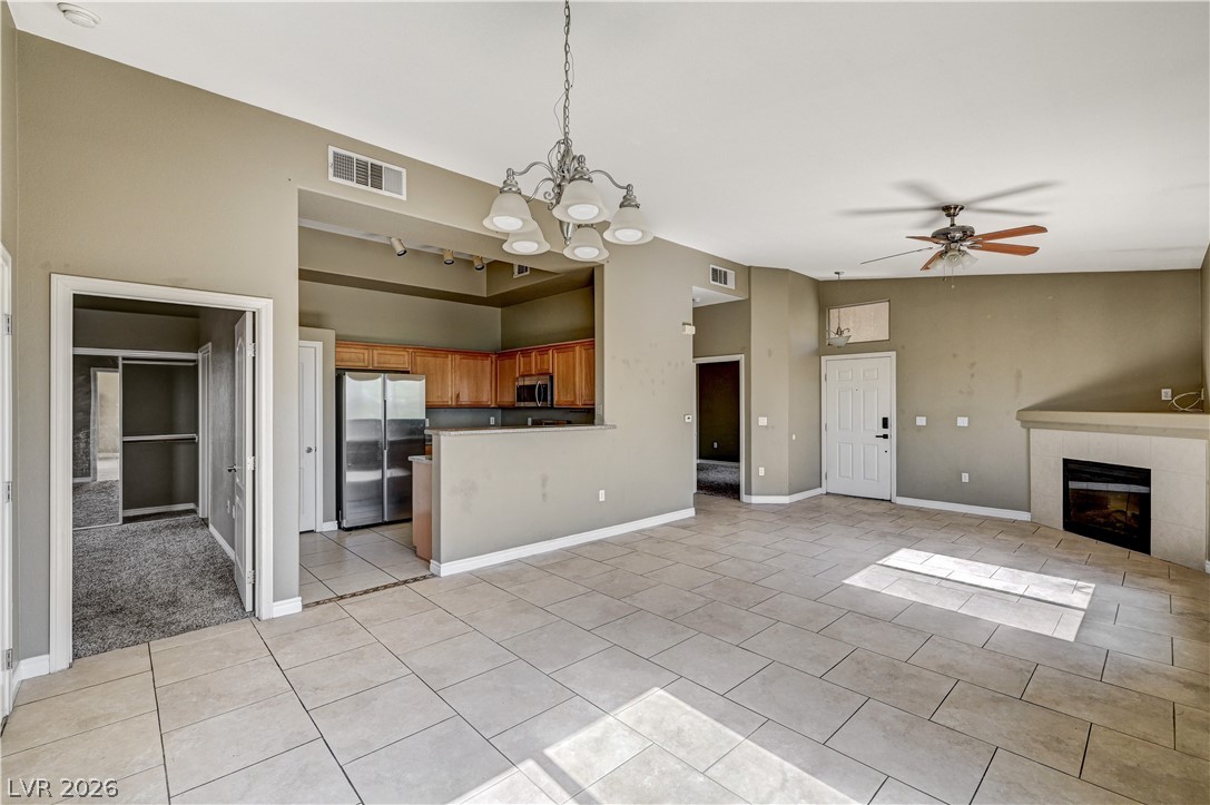 8985 South Durango Drive, Unit 2187 Las Vegas, NV 89113 - Photo 73 of 73 An open floorplan seamlessly connects the kitchen and living area, featuring tile flooring and a cozy fireplace.