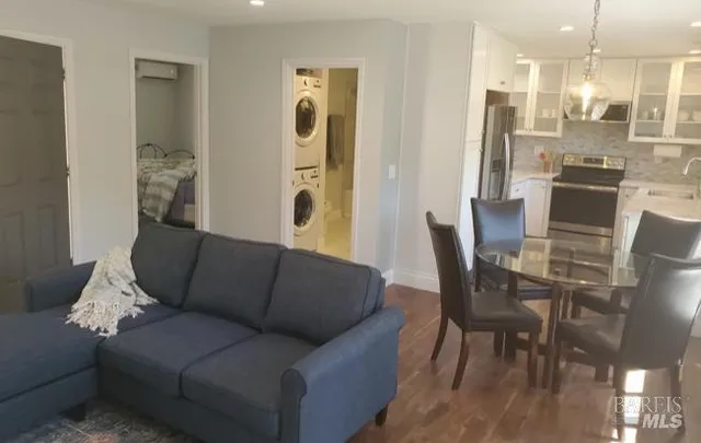 a living room with furniture and a view of kitchen