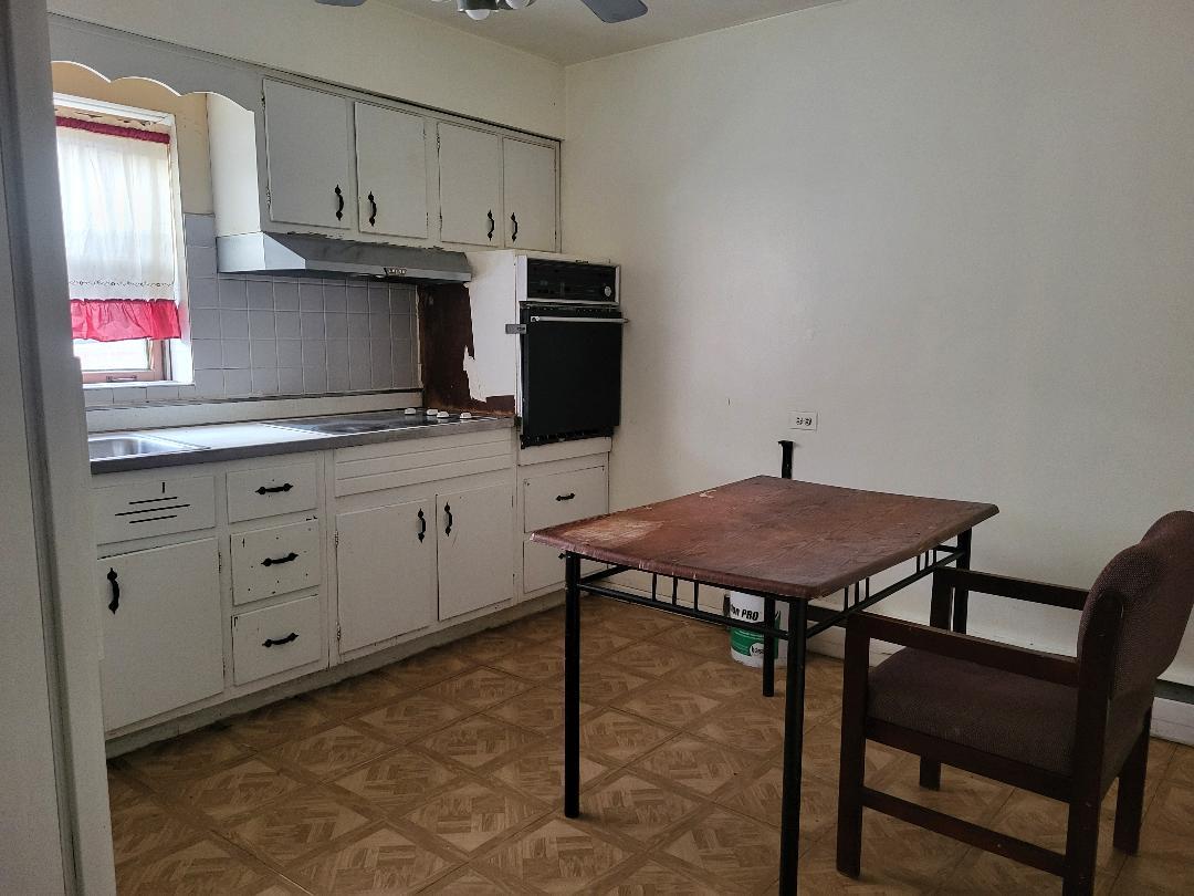 3512 Warren Avenue, Unit 5 Bellwood, IL 60104 - Photo 3 of 7 a kitchen with cabinets and wooden floor