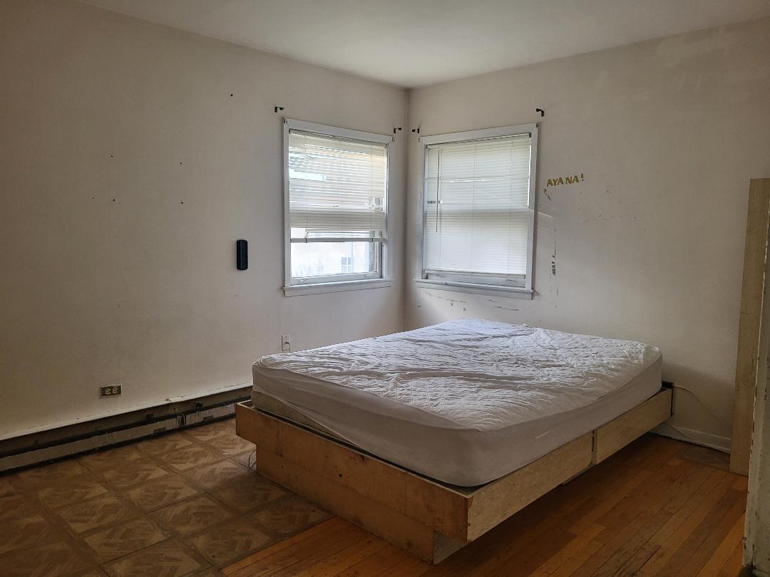 3512 Warren Avenue, Unit 5 Bellwood, IL 60104 - Photo 7 of 7 a bed sitting in a bedroom next to a window