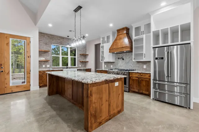 a kitchen with kitchen island granite countertop a stove and a sink