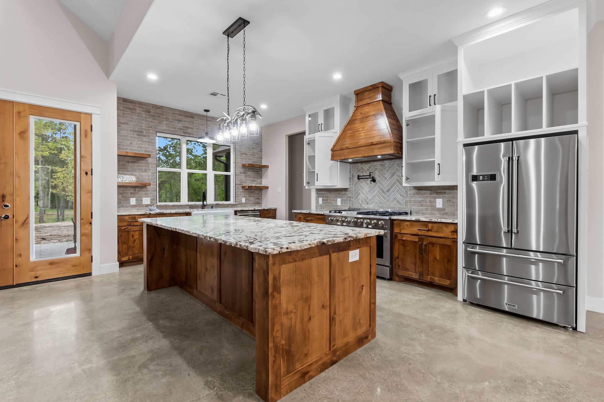 393 Hanson Road Onalaska, TX 77360 - Photo 13 of 38 a kitchen with kitchen island granite countertop a stove and a sink