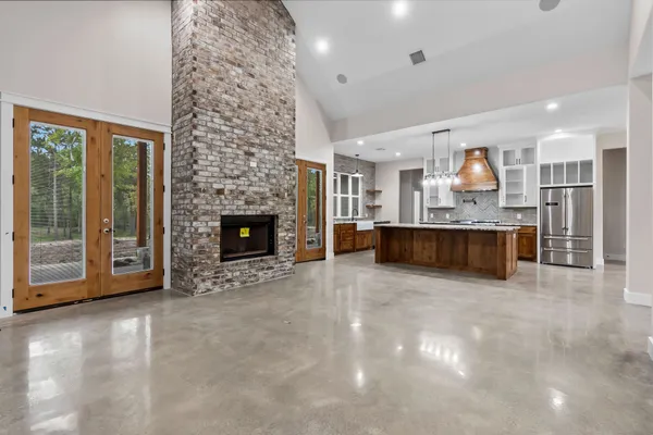 a large kitchen with a fireplace and a to ceiling window