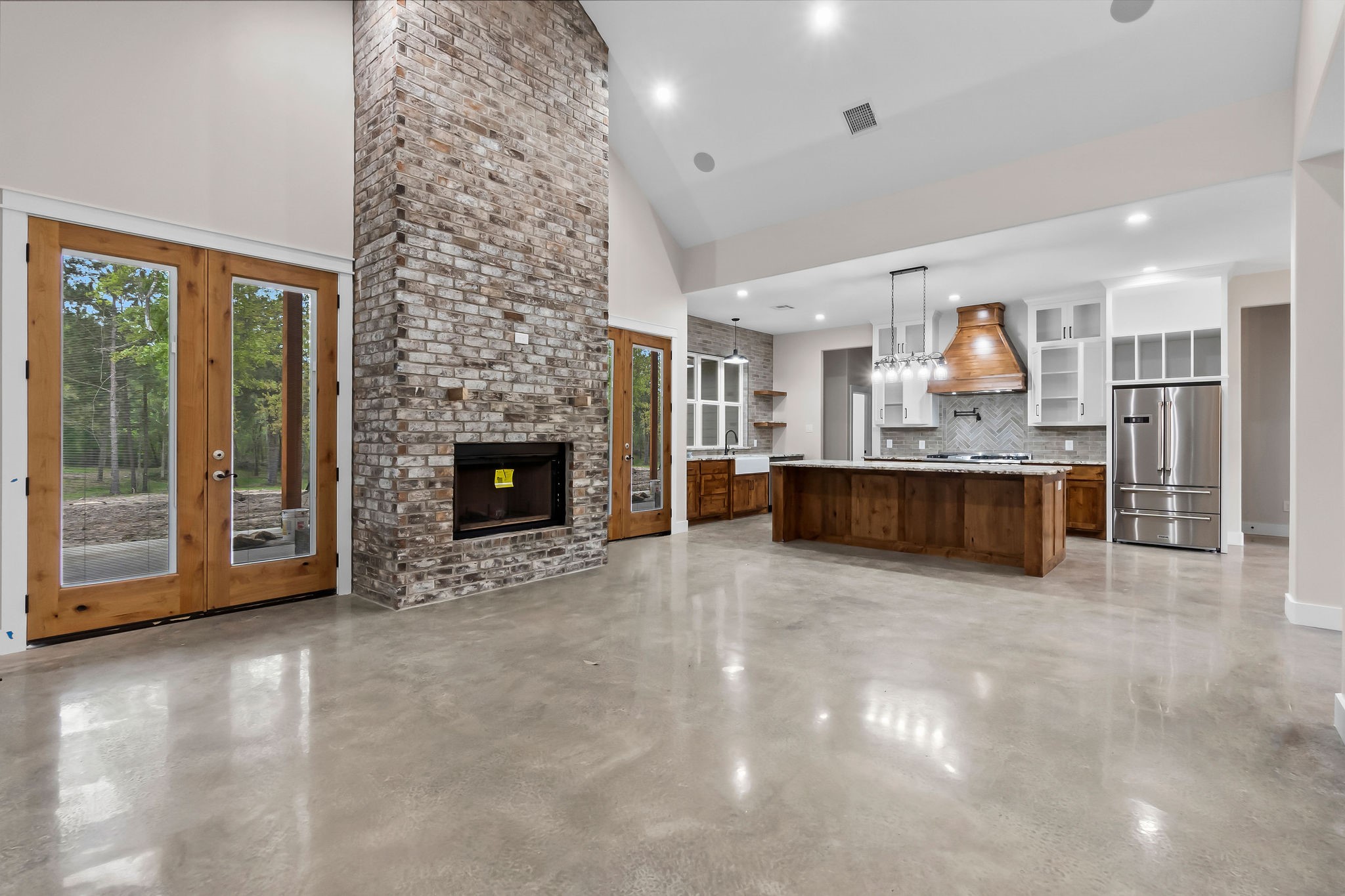 393 Hanson Road Onalaska, TX 77360 - Photo 17 of 38 a large kitchen with a fireplace and a to ceiling window