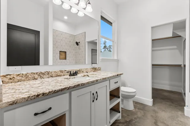a bathroom with a granite countertop sink and a mirror