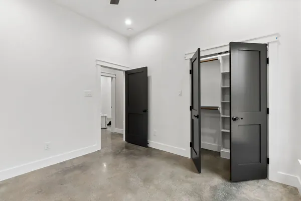 an empty room with closet and a hallway