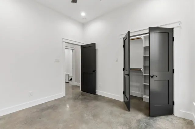 an empty room with closet and a hallway