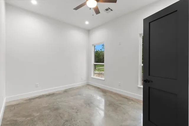 an empty room with a ceiling fan and a window