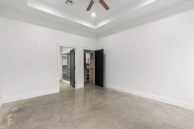 an empty room with closet and a ceiling fan