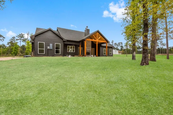 a front of a house with a yard and trees